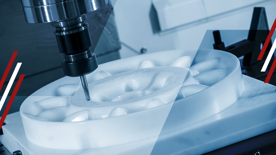 CNC milling machine spindle cutting a white plastic part on a worktable, close-up in an industrial workshop