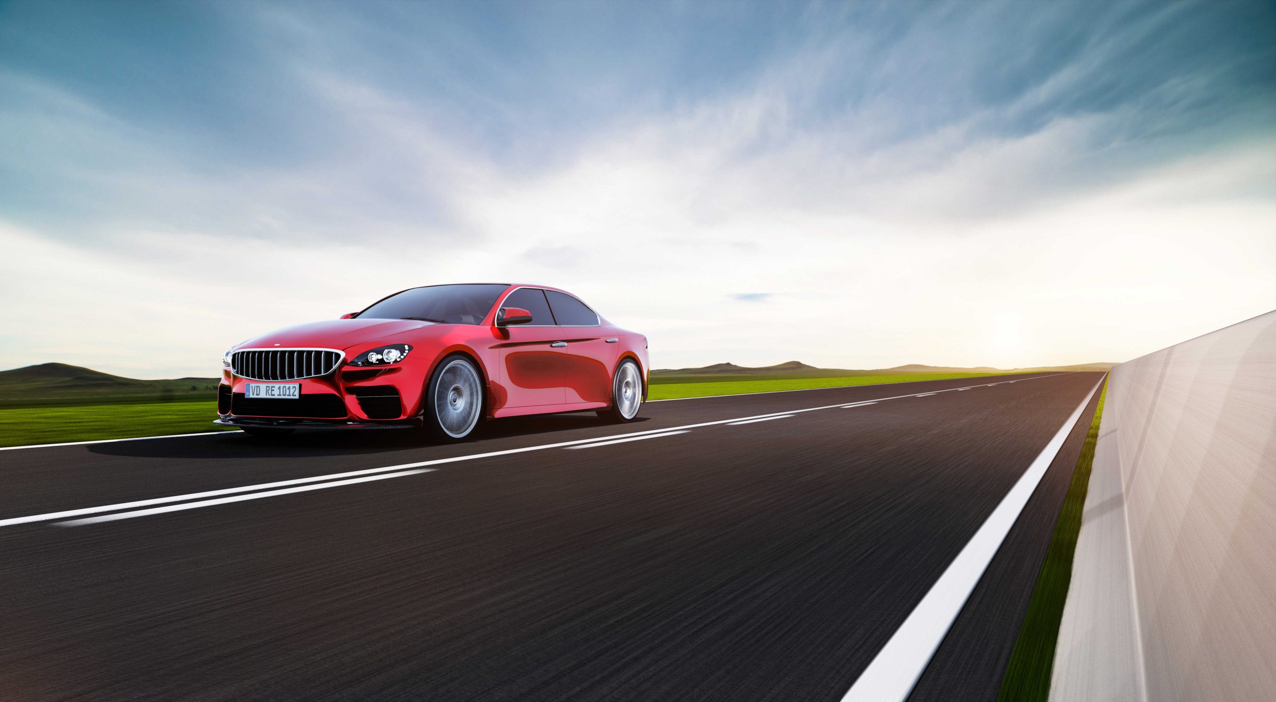 Red sports sedan driving fast on an open highway through green fields under a bright sky