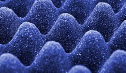 Blue acoustic foam soundproofing panel with egg-crate texture close-up
