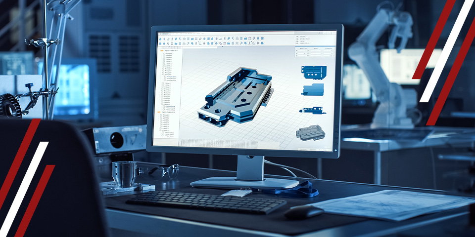 CAD model of a machined metal part on a computer monitor in a workshop, with tools and robotic arm in the background