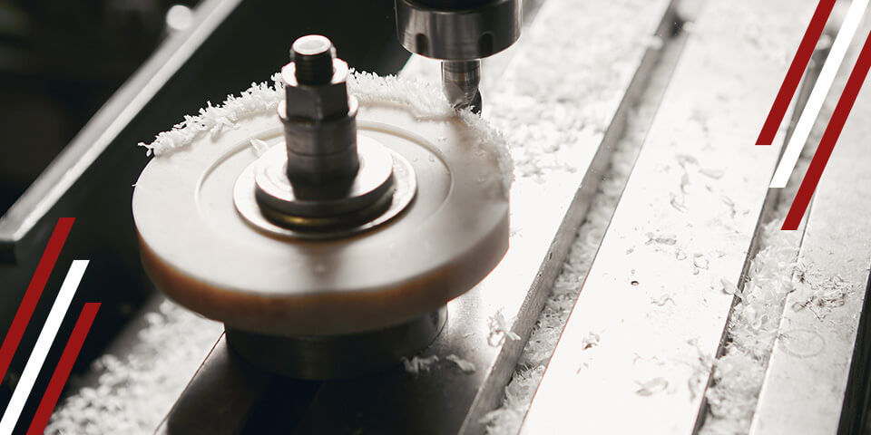 Close-up of CNC milling machine cutting metal, with shavings and tool head in motion on a precision machining bed